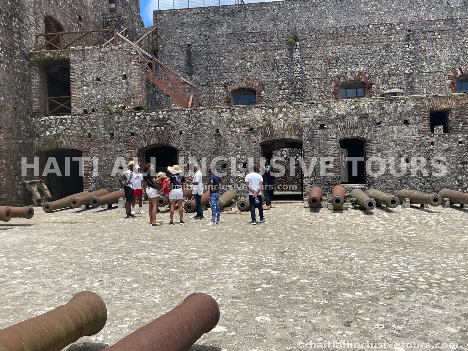 Guests with their guide beside the historic cannons in the Citadelle courtyard