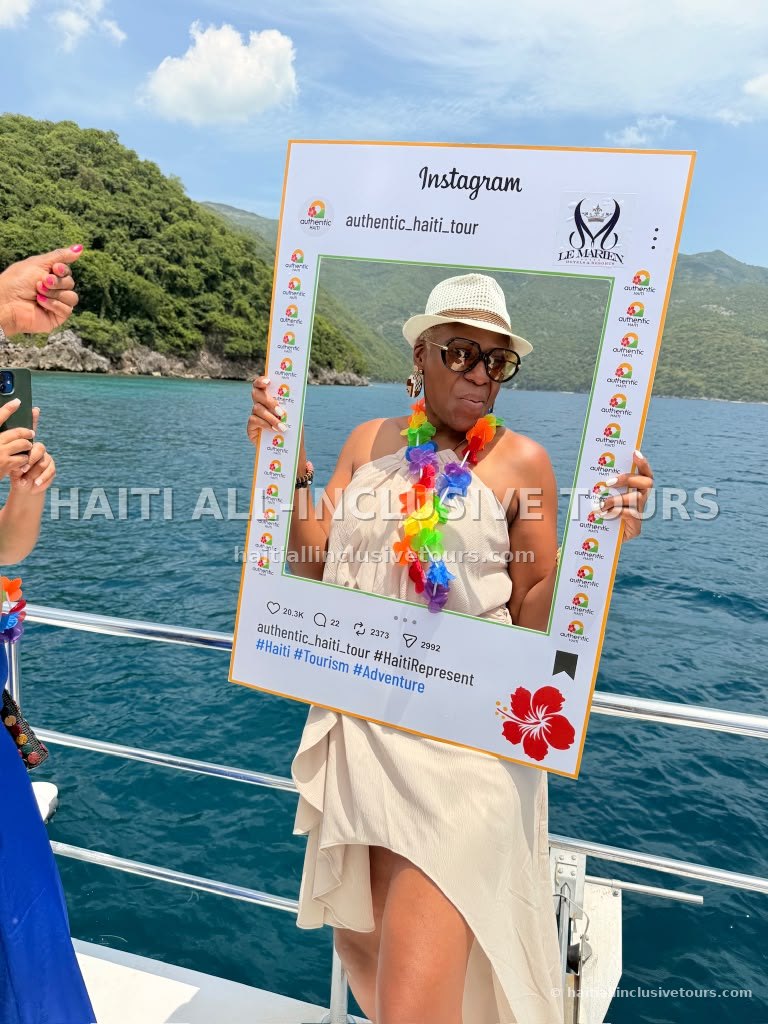 Guest posing with an Authentic Haiti Tour and Le Marien Hotel photo frame on deck